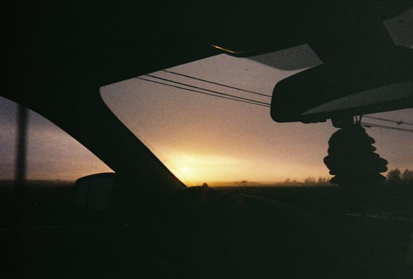 A sunset from the passenger seat of a car